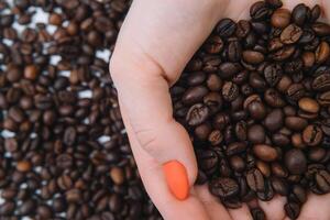 Coffee beans in woman's hands. photo