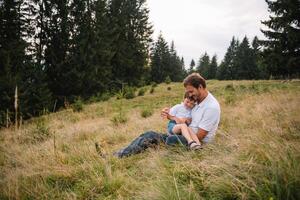 Happy father and little child are walking in the mountains. Father's Day. vacation in the national park photo