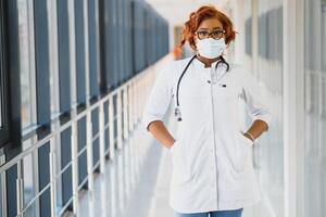 Young attractive african doctor with face mask photo