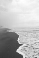 black and white photo of storm over the beach