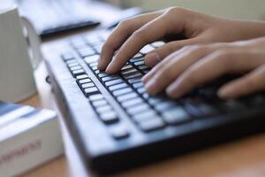 manos escribiendo en un teclado de computadora foto