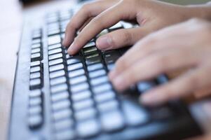 manos escribiendo en un teclado de computadora foto