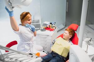 chico satisfecho con el Servicio en el dental oficina. concepto de pediátrico dental tratamiento foto