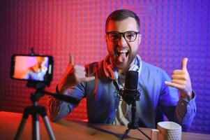 A video blogger records content in his studio. The backstage photo was taken from behind one of the participants in the shooting, at the beginning of the shooting when the blogger is preparing.