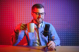 A video blogger records content in his studio. The host of the video blog is a young man who is very enthusiastic about telling his subscribers a story. photo