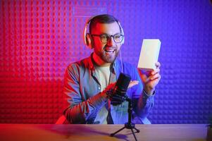 A video blogger records content in his studio. The host of the video blog is a young man who is very enthusiastic about telling his subscribers a story. photo