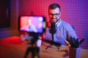 A video blogger records content in his studio. The backstage photo was taken from behind one of the participants in the shooting, at the beginning of the shooting when the blogger is preparing.