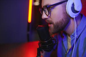 A video blogger records content in his studio. The host of the video blog is a young man who is very enthusiastic about telling his subscribers a story. photo