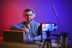 Young man recording or streaming podcast using microphone at his small broadcast studio. Content creator. photo