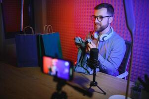 joven hombre grabación o transmisión podcast utilizando micrófono a su pequeño transmitir estudio. contenido creador. foto