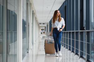 Pretty young female passenger at the airport photo