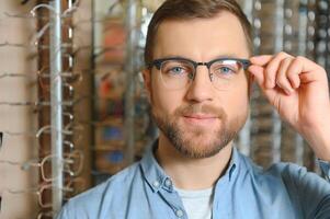 Satisfied Customer. Over the shoulder view of happy young male client wearing new glasses. photo