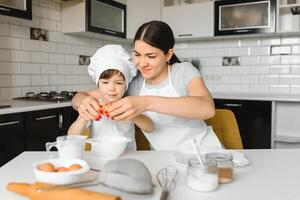 contento familia. madre enseñando su hijo cómo a Cocinando pastel menú en Mañana. sano estilo de vida concepto.. horneando Navidad pastel y cocinar concepto foto