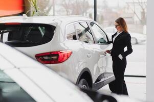 business woman in auto salon. concept of female driver photo