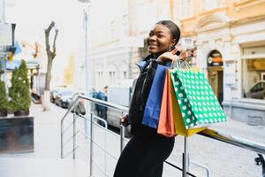 A shopping black woman carrying shopping bags outdoor photo