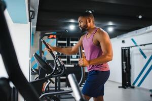 Weight training African doing bodybuilding in gym. photo