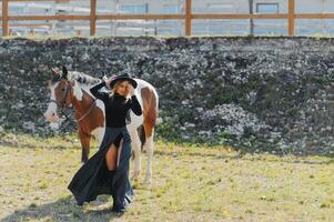 Fashionable portrait of a beautiful young woman and horse photo