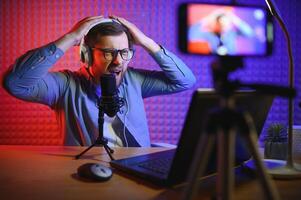 A video blogger records content in his studio. The host of the video blog is a young man who is very enthusiastic about telling his subscribers a story. photo