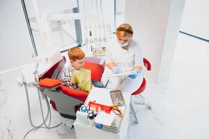 Little boy having his teeth examined by a dentist photo