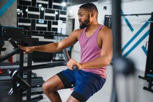 african man using stationary bicycle in a gym photo