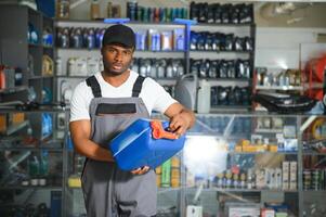 retrato de un hermoso africano vendedor en un auto partes almacenar. el concepto de coche reparar foto