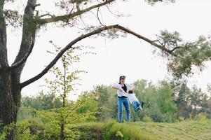 elegante madre y hermoso hijo teniendo divertido en el naturaleza. contento familia concepto. belleza naturaleza escena con familia al aire libre estilo de vida. contento familia descansando juntos. felicidad y armonía en familia vida. foto