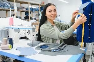 Seamstress at work. Dressmaker making clothes in modern studio. photo