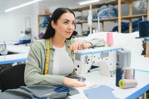 Portrait of a beautiful seamstress carrying a tape measure and working in a textile factory photo