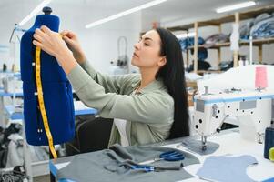 Seamstress at work. Dressmaker making clothes in modern studio. photo