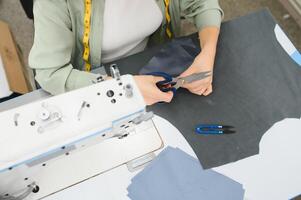 Portrait of a beautiful seamstress carrying a tape measure and working in a textile factory photo