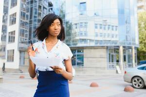 business black woman holding a cup of coffee and files photo