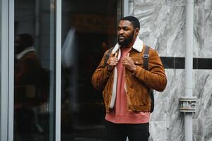 portrait of confident trendy serious african guy in stylish outfit, young afro american male posing at camera, looking away photo