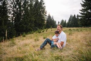 Happy father and little child are walking in the mountains. Father's Day. vacation in the national park photo