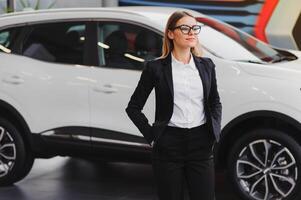 business woman in auto salon. concept of female driver photo