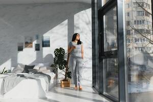 Beautiful young woman drinking fresh juice in bedroom photo