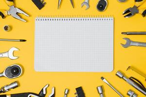 Tools top view on yellow background. Plier, open wrenches, screwdrivers and staple gun flat lay with copy space photo