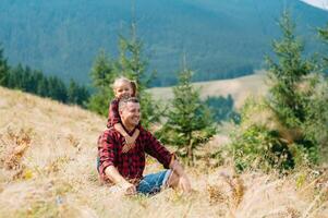 Happy father and little child are walking in the mountains. Father's Day. vacation in the national park photo