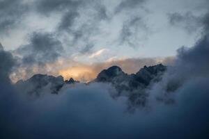 el Dom brilla mediante el nubes encima un montaña rango foto