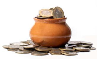 Coins in a clay pot on a white background, money saving concept. photo