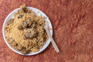 Indian famous mutton biryani dish served on white plate is delicious and fragrant. photo