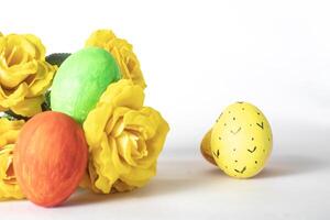 Easter eggs and yellow roses isolated on white background with copy space. photo