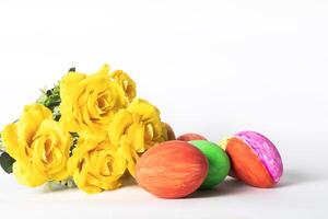 Easter eggs and yellow roses isolated on white background with copy space. photo