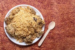 Mutton Biryani is a delicious and fragrant Indian famous dish served on a white plate photo