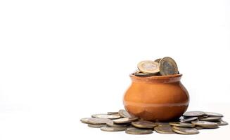 Coins in a clay pot on a white background with copy space. business and finance concept photo