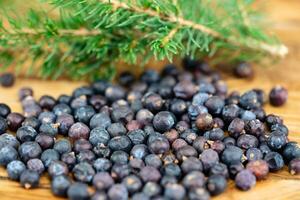 dried juniper berries on olive wood photo