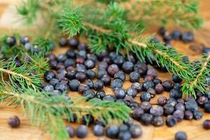 dried juniper berries on olive wood photo