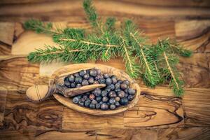 dried juniper berries on olive wood photo