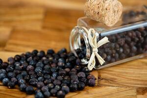 dried juniper berries on olive wood photo