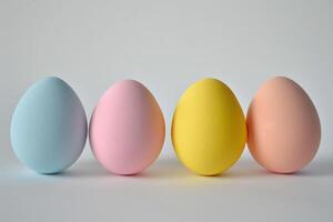 ai generado cuatro pastel de colores huevos en un fila invocar un suave, festivo Pascua de Resurrección espíritu, ideal para primavera temas, Copiar espacio foto