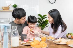 ocupaciones juntos durante el vacaciones. padres y niños son teniendo un comida juntos durante el vacaciones. madre preparar Leche para hijo en mañana, disfrutar, fin de semana, vacante, familia tiempo, contento. foto